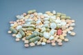 Close up of a pile of different medicine pills on a light blue surface - the concept of health Royalty Free Stock Photo