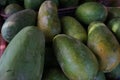 Close up of a pile of fresh local papaya fruit in a fruit basket in a traditional fruit shop for sale