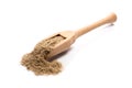 Close-up of pile of ground cardamom spice in a wooden spoon on w