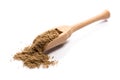 Close-up of pile of ground cumin spice in a wooden spoon on whit