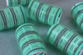 Close-up of pile of hair curlers on green background. Green curlers.