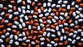 A close up of a pile of orange and white pills