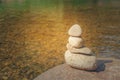 Close up pile of pebbles with clear water of river in the background.