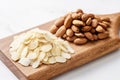 Close-up of a pile of raw almond flakes and whole almond nuts on a wooden board. Low angle view Royalty Free Stock Photo