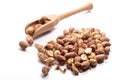 Close-up of pile of roasted, salted peanuts in a wooden spoon on