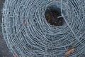 Close up on a pile roll of shiny new barbed wire for fence fencing. Security protection law enforcement. Prison jail Royalty Free Stock Photo