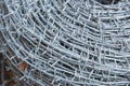 Close up on a pile roll of shiny new barbed wire for fence fencing. Security protection law enforcement. Prison jail Royalty Free Stock Photo