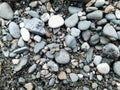 Close up pile of smooth small stones on black sand Royalty Free Stock Photo