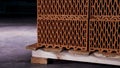 Close up of a pile of stacked clay bricks with holes placed on wooden pallet in dark storage room. Stock footage. Close