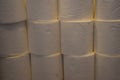 A close up of a pile of toilet paper rolls stacked in a bathroom. Toilet paper panic buying and hoarding