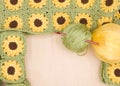 Balls of yarn with crochet hook next to finished hand crochet sunflower granny squares Royalty Free Stock Photo