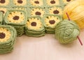 piles of hand crochet granny squares with yellow flowers stacked