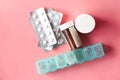 Close up of pills , container and pill box on pink background