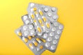 Close-up pills in packages on a bright yellow background. Different antibiotics, and prescription drugs in yellow background.