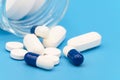 Close up of Pills spilling out of pill bottle on blue background. with copy space. Medicine concept. Royalty Free Stock Photo