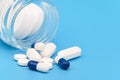 Close up of Pills spilling out of pill bottle on blue background. with copy space. Medicine concept. Royalty Free Stock Photo