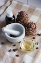 close-up, pine cones with nuts, glass bottle and mortar on a table on a wooden background