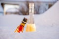 A bottle of fruit cocktail and whisky in the snow Royalty Free Stock Photo