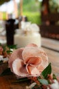 Close-up of pink fabric rose and white flowers on rustic table. Spa set in blurred backgound