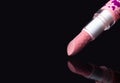 Close-up pink lipstick with heart prints design isolated on black background. Close up. Macro. Detailed photo of make up product