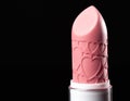 Close-up pink lipstick with heart prints design isolated on black background. Close up. Macro. Detailed photo of make up product