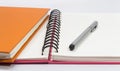 Close-up of pink, orange open note book and pen Royalty Free Stock Photo