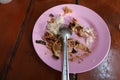 Close-up of pink plastic plates and utensils that have been eaten on the dining table. Royalty Free Stock Photo