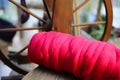 Close up of pink red ball raw merino wool, blurred spinning wheel background Royalty Free Stock Photo