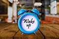 Wake up text on Alarm Clock on wooden table Royalty Free Stock Photo