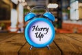 Hurry up text on Alarm Clock on wooden table. Royalty Free Stock Photo