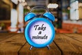 Take a minute text on Alarm Clock on wooden table. Royalty Free Stock Photo