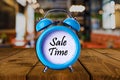 Sale time text on Alarm Clock on wooden table. Royalty Free Stock Photo