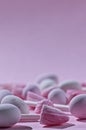 Close up of pink and white candies on pink background with copy space and selective focus