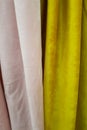Close-up of pink and yellow, velvet curtains thin and thick vertical folds of dense fabric. Textured abstract backgrounds and