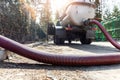 Close-up pipe hose of sewage truck car engine emptying home sewerage tank. Septic cleaning vacuum service and Royalty Free Stock Photo