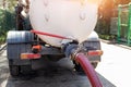 Close-up pipe hose of sewage truck car engine emptying home sewerage tank. Septic cleaning vacuum service and Royalty Free Stock Photo