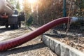 Close-up pipe hose of sewage truck car engine emptying home sewerage tank. Septic cleaning vacuum service and Royalty Free Stock Photo