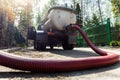 Close-up pipe hose of sewage truck car engine emptying home sewerage tank. Septic cleaning vacuum service and Royalty Free Stock Photo