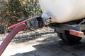 Close-up pipe hose of sewage truck car engine emptying home sewerage tank. Septic cleaning vacuum service and