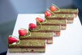 Close-up of pistachio chocolate dessert with strawberries and nuts, catering table setting Royalty Free Stock Photo