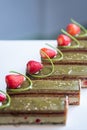 Close-up of pistachio chocolate dessert with strawberries and nuts, catering table setting Royalty Free Stock Photo