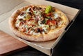 Close-up of pizza in takeout box with sausage, bacon, black olives and cheese Royalty Free Stock Photo