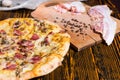 Close up of pizza on wooden table, near lie cutting board with b Royalty Free Stock Photo