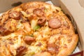 Close up of pizzas with variety of toppings and cheese in cardboard take out boxes with open lid Royalty Free Stock Photo