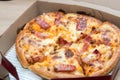 Close up of pizzas with variety of toppings and cheese in cardboard take out boxes with open lid Royalty Free Stock Photo