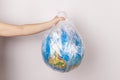 a close-up of the planet earth in the form of a globe in a plastic bag. the concept of saving the planet from an