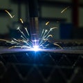 A close-up of a plasma cutting process, showcasing a plasma torch emitting bright Royalty Free Stock Photo