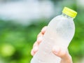 Close-up plastic water bottle in woman hand after jogging in garden backgroound Royalty Free Stock Photo