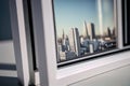 close-up of plastic window frame, with the view of a busy city visible through it