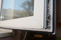 A close-up on a plastic window profile corner with a locking mechanism and a seal